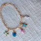 A gold bracelet with shell, star and conch shell charms