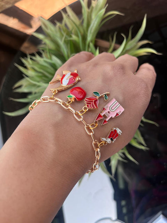 gold paper clip bracelet with a bunny charm, castle charm, rose charm, fish charm and apple charm