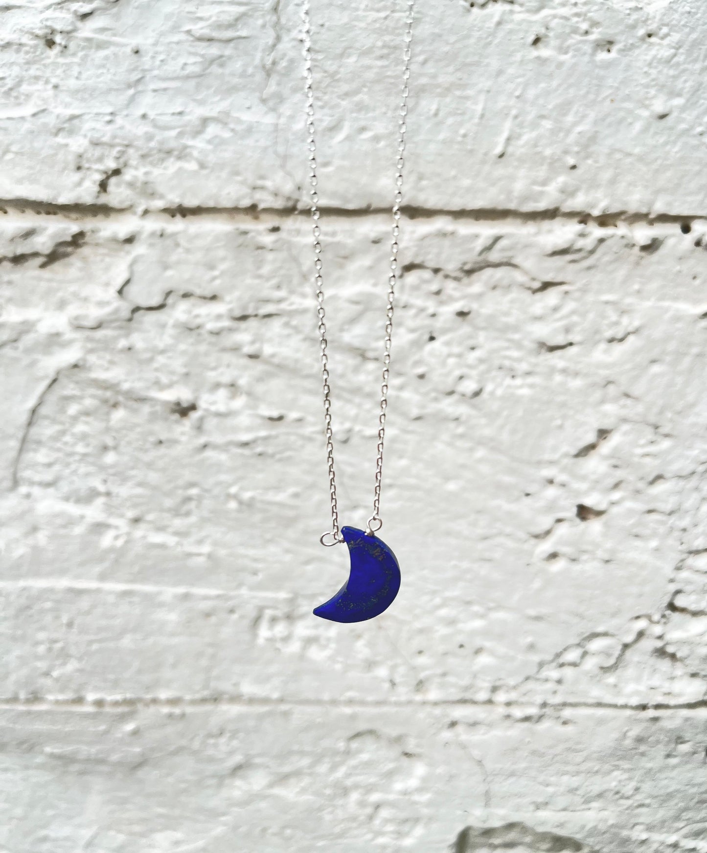 Half moon lapis lazuli necklace with a deep blue crescent shaped stone 