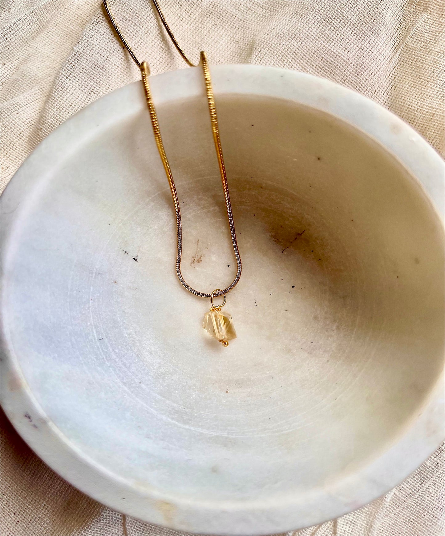 Golden citrine necklace with a faceted gemstone pendant on a delicate chain