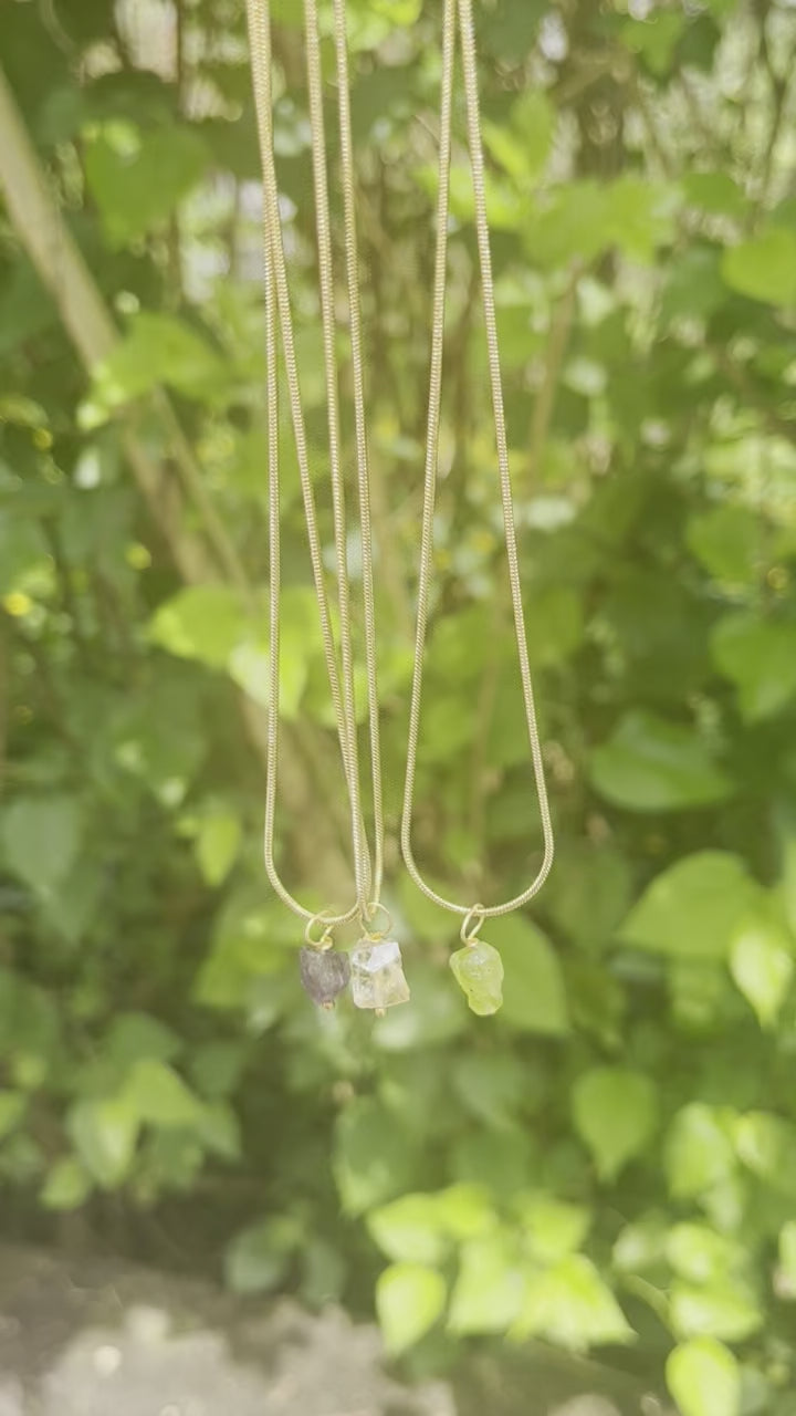 Amethyst necklace featuring a faceted purple gemstone pendant on a delicate gold chain