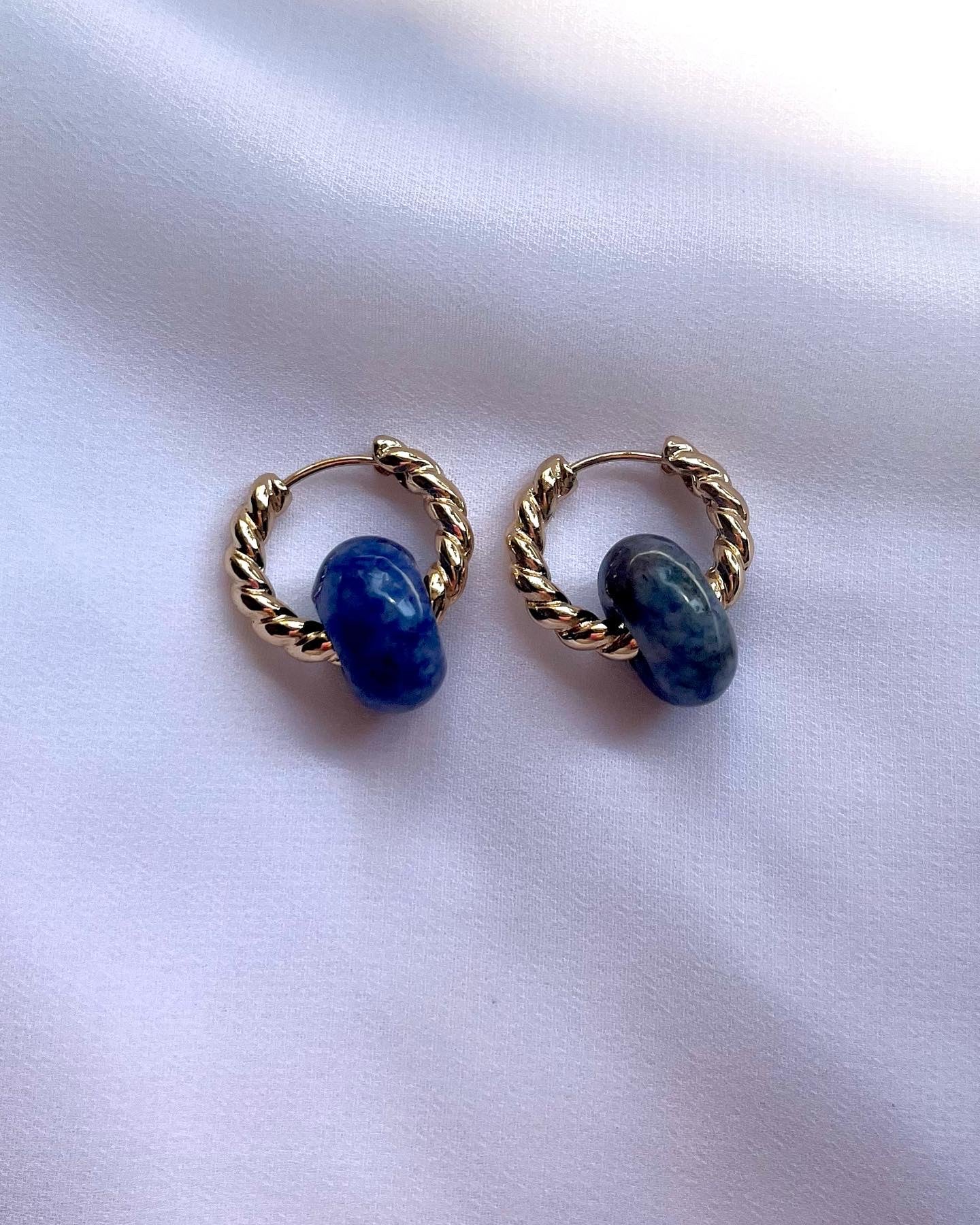 Pair of gold huggie earrings with lapis lazuli gemstones