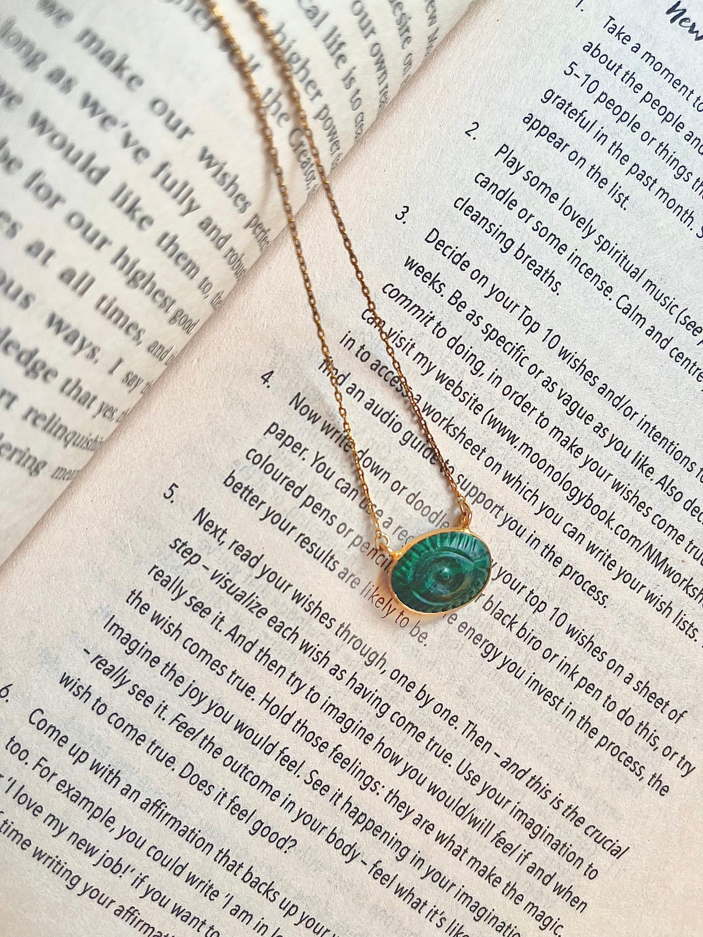 Malachite evil eye necklace featuring a green and black eye-shaped charm on a dainty gold chain