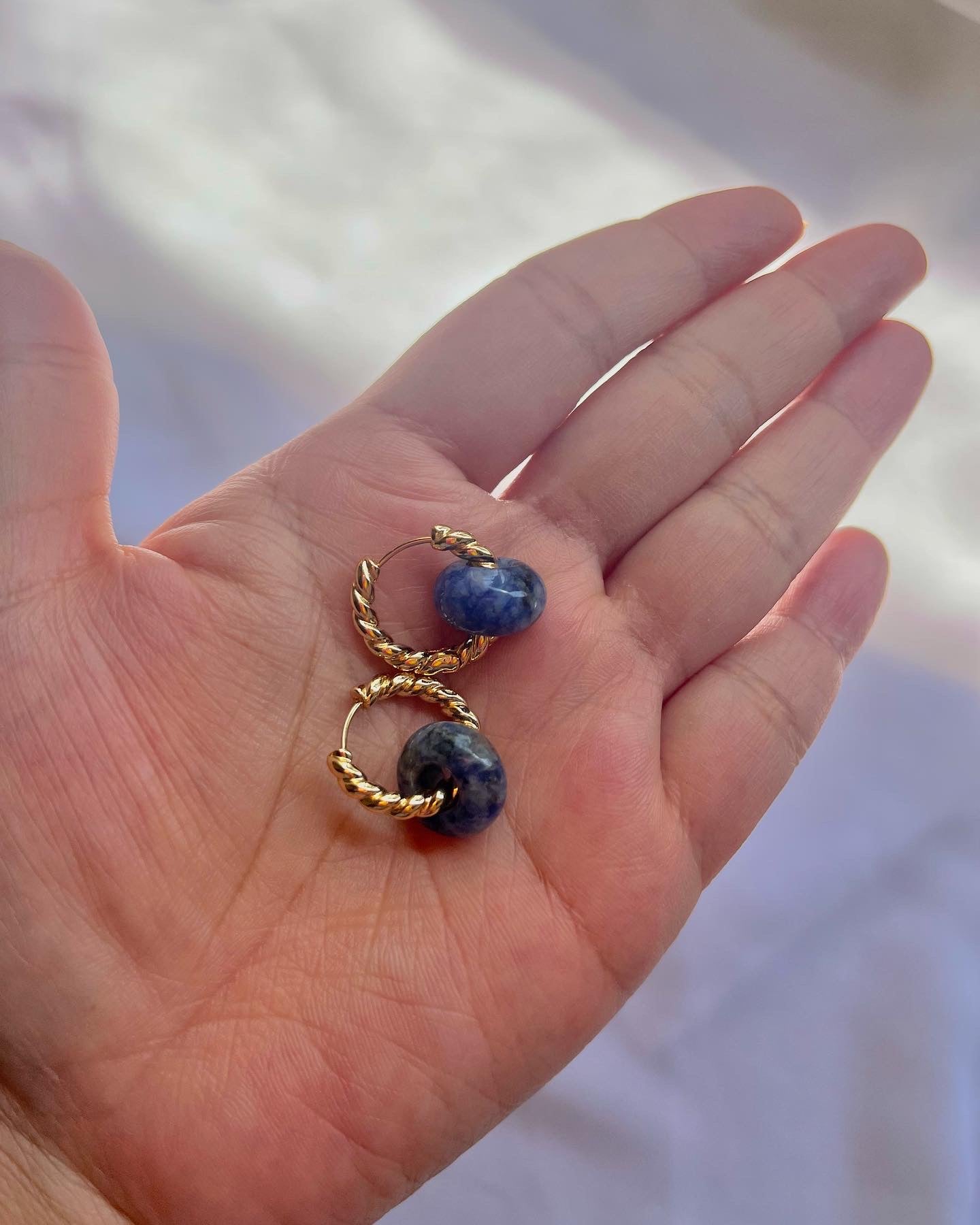 Pair of gold huggie earrings with lapis lazuli gemstones