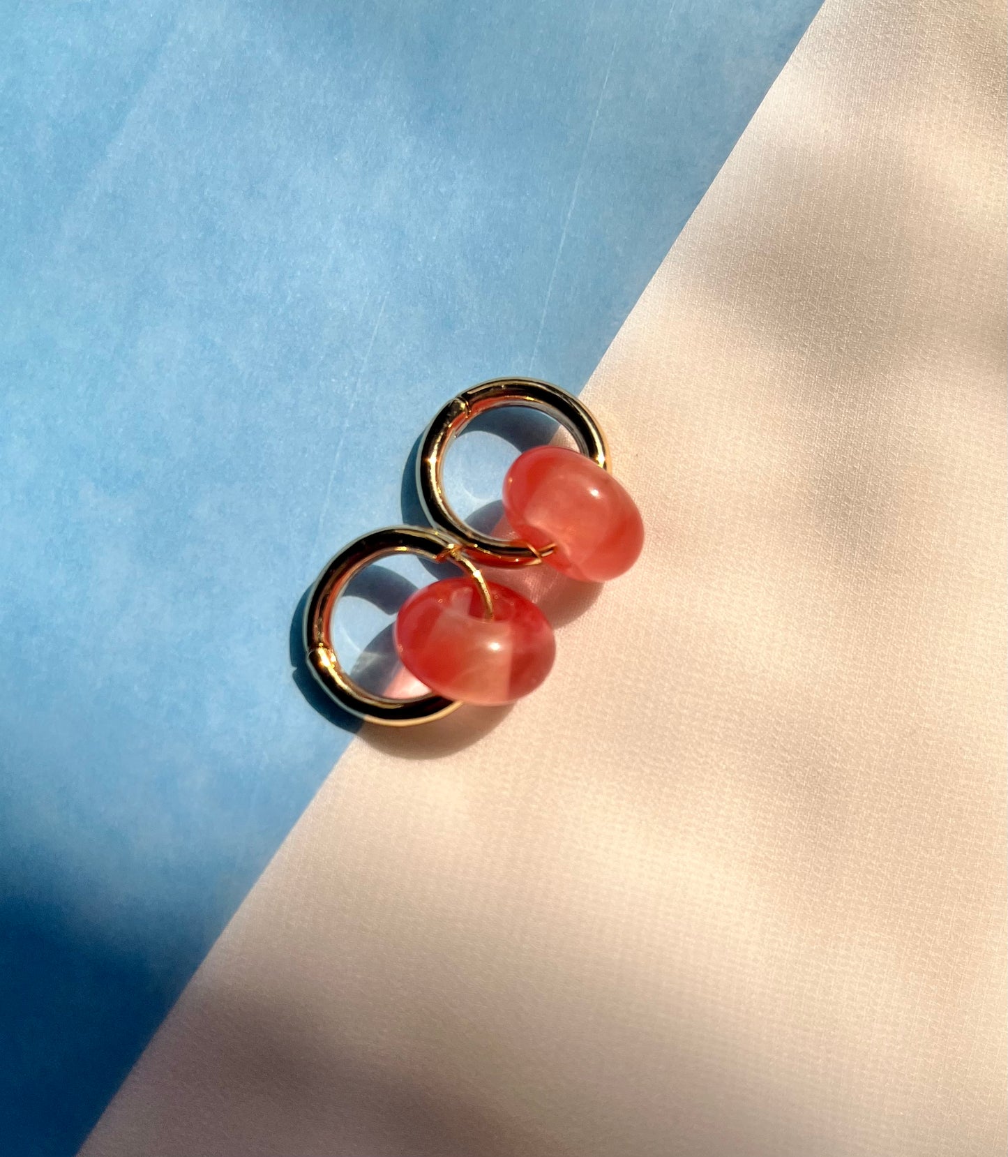 Rose quartz huggies with small pink stones set in gold hoop earrings