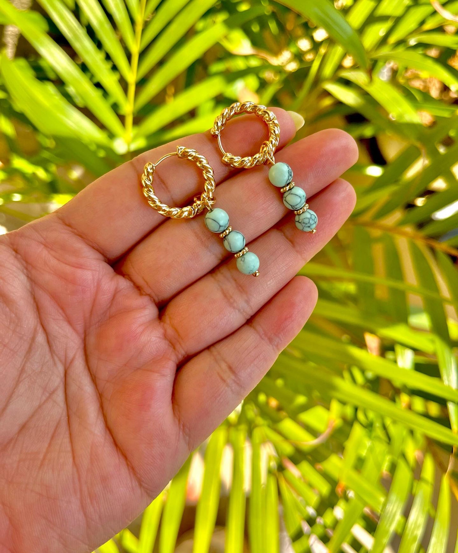 Turquoise huggies with small blue stones set in gold hoop earrings